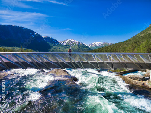 Girl on bridge above waterfall