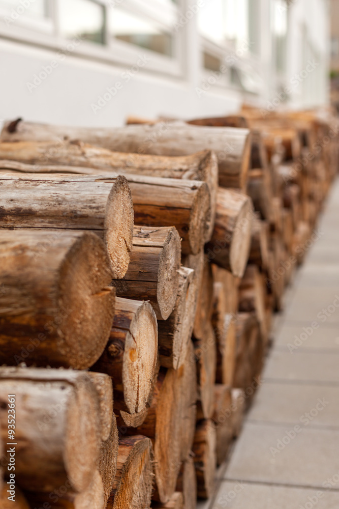 Logs woodpile near modern building house wall