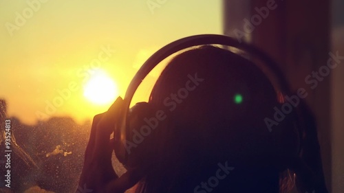 Attractive young woman wears headphones listening to music on