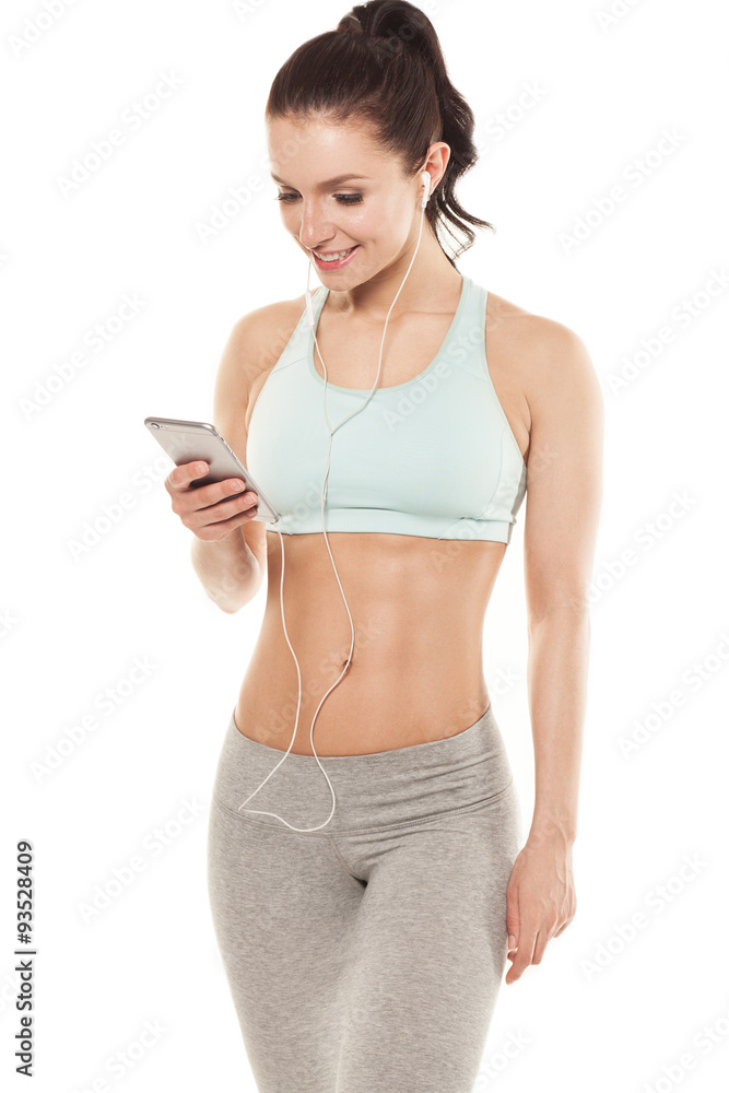fitness girl with a smartphone on a white background, enjoys sports training, gym workout