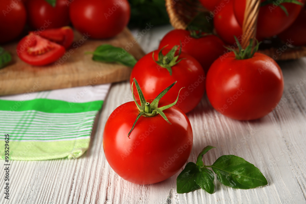 Whole and sliced red tomatoes on cutting board closeup Whole and sliced red tomatoes on cutting board closeup