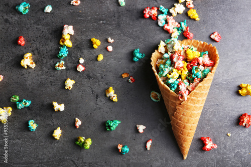 Coloured popcorn in the waffle cup on dark background