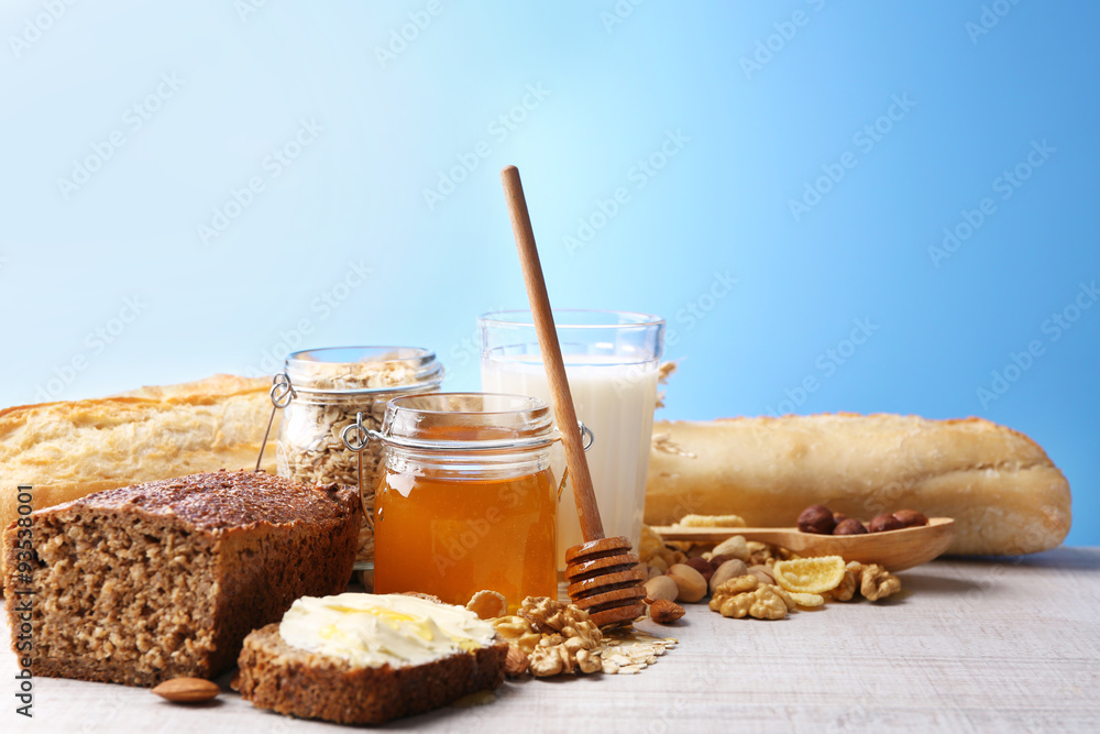 Healthy breakfast with bread, honey, nuts on table, on colorful background. Country breakfast concept Healthy breakfast with bread, honey, nuts on table, on colorful background. Country breakfast concept