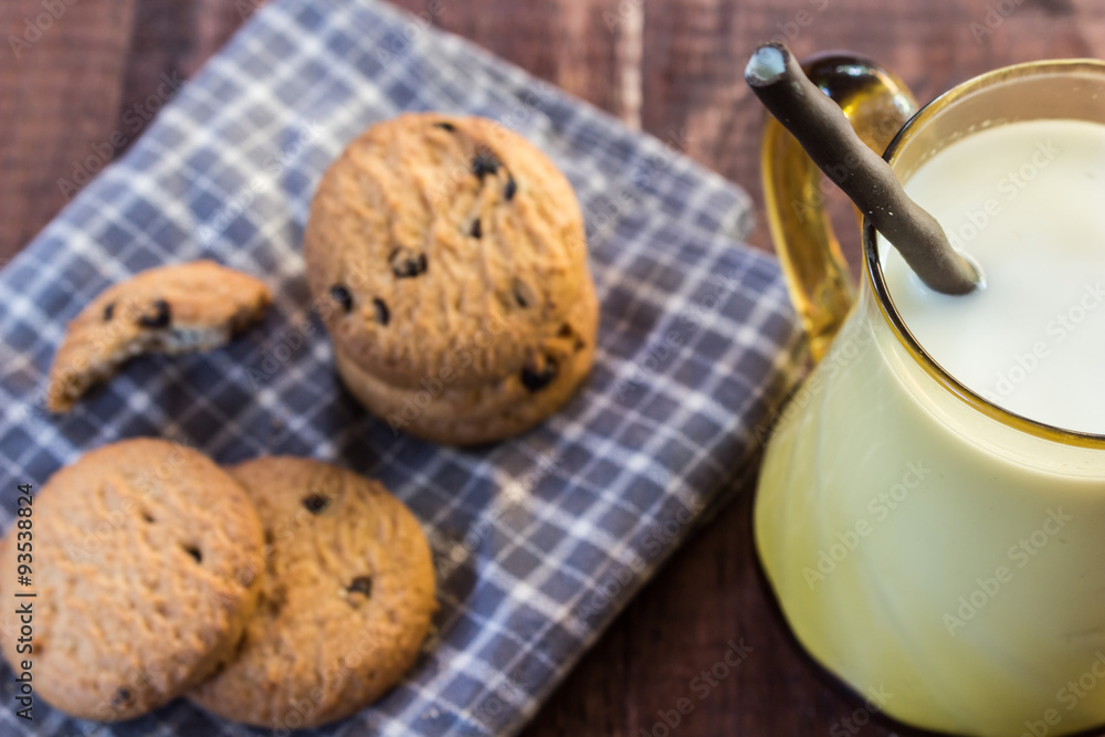 Close up cookies and glass of milk on wooden table Close up cookies and glass of milk on wooden table