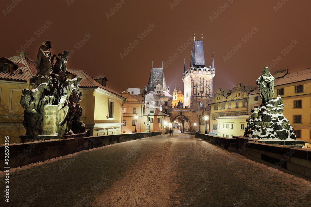 Night snowy Prague with Bridge Tower, St. Nicholas' Cathedral and gothic Castle from Charles Bridgel, Czech republic