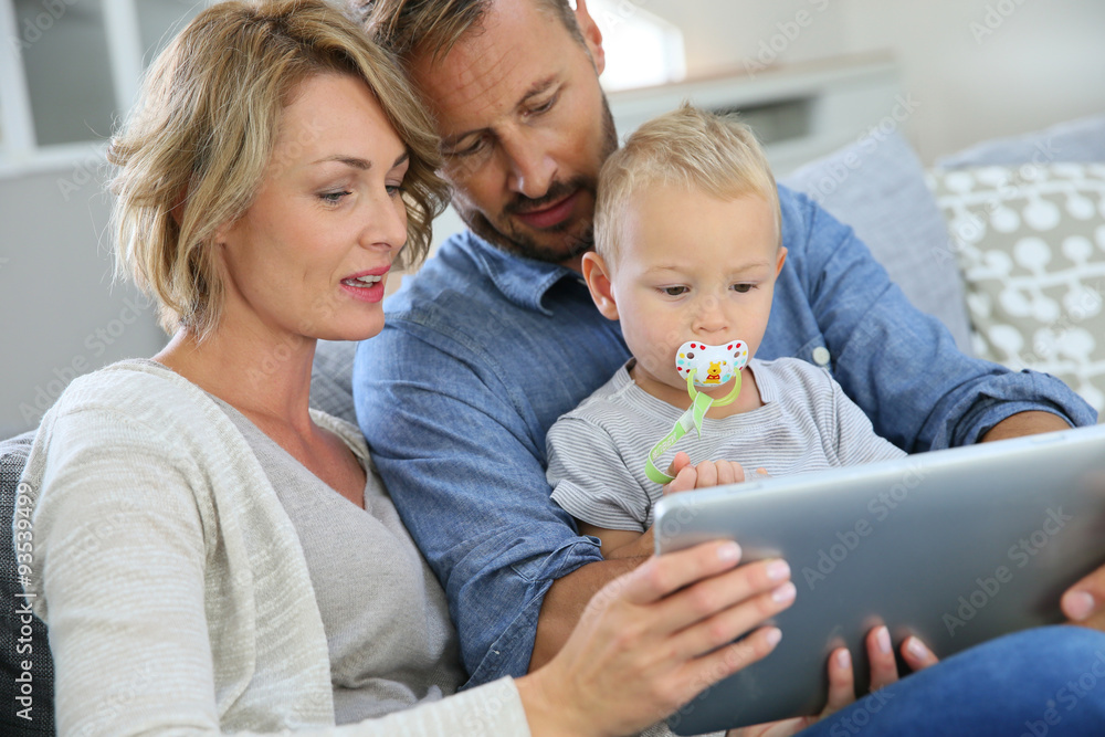 Parents with baby boy playing with digital tablet Parents with baby boy playing with digital tablet