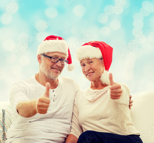 happy senior couple in santa helper hats