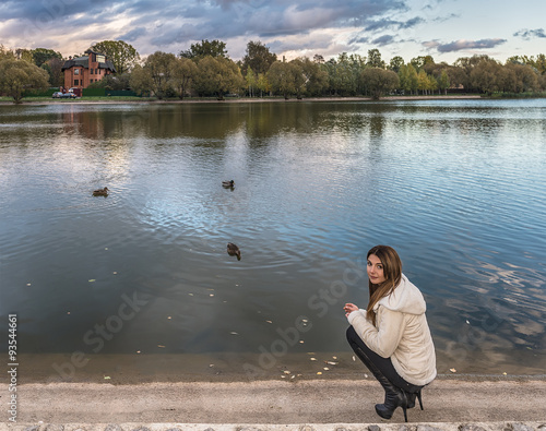 Moscow. Autumn. The girl in a warm jacket wants to feed ducks on a Meshchersky pond.