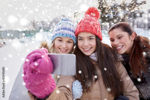 happy teenage girls taking selfie with smartphone