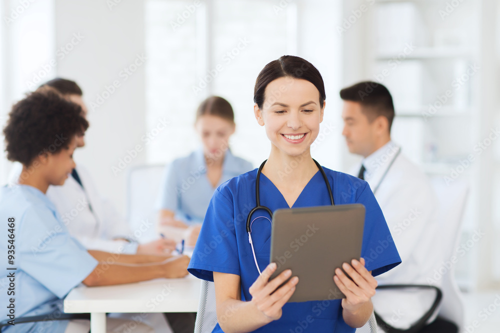 happy doctor with tablet pc over team at clinic happy doctor with tablet pc over team at clinic