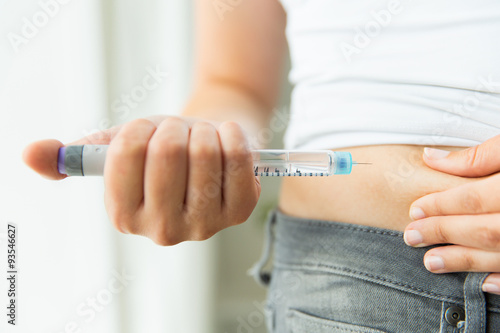 close up of hands making injection by insulin pen