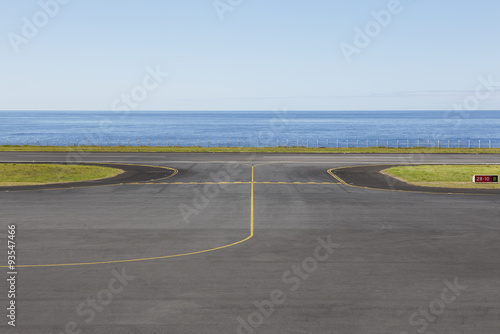 Fotografija Airport runway close to the ocean with lines and fence