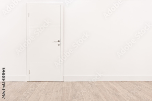 White door and a light brown hardwood floor