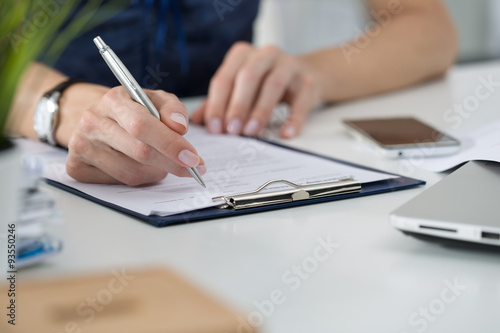Woman writing something sitting at her office