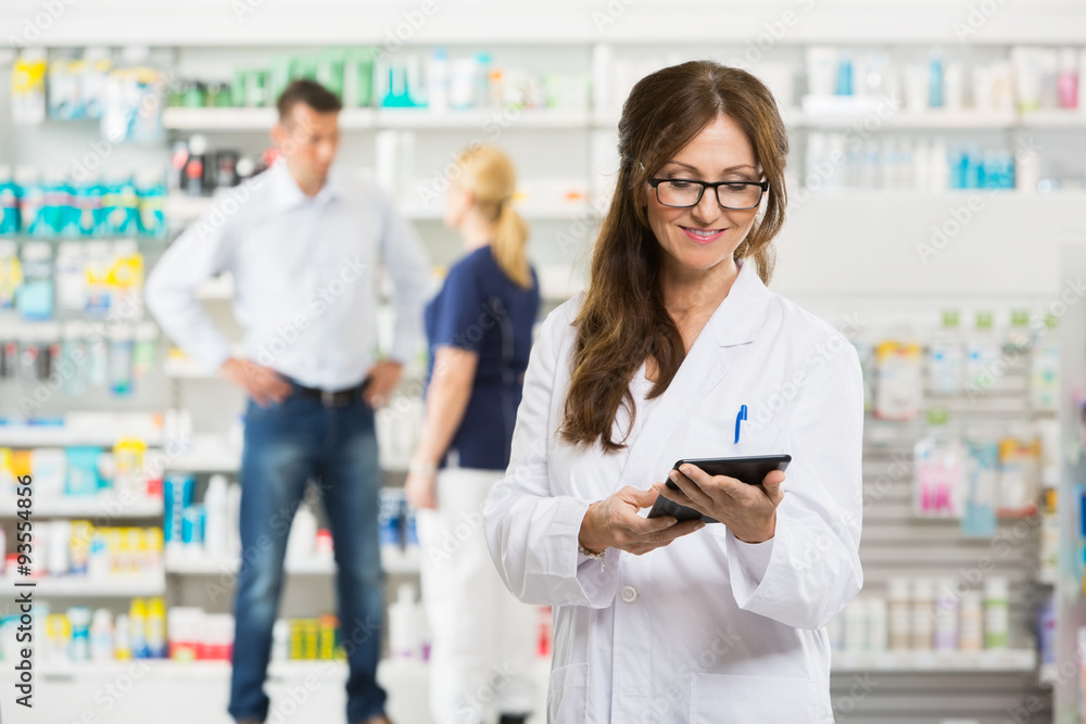 Female Pharmacist Holding Digital Tablet At Pharmacy