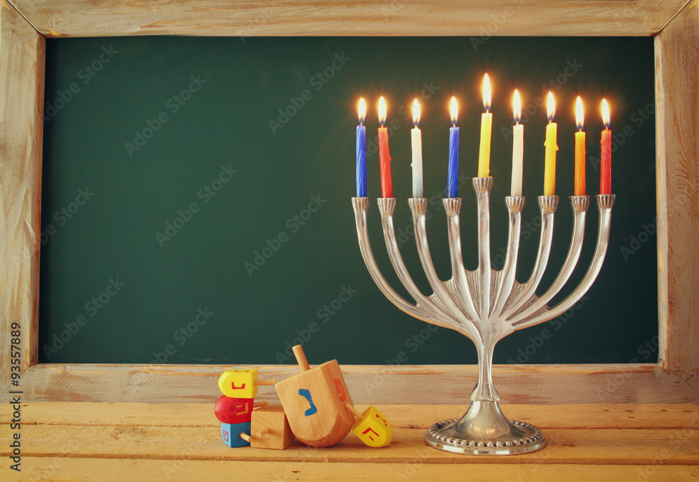low key image of jewish holiday Hanukkah with menorah (traditional Candelabra) and wooden dreidels spinning top with chalkboard background, room for text
low key image of jewish holiday Hanukkah with menorah (traditional Candelabra) and wooden dreidels spinning top with chalkboard background, room for text
