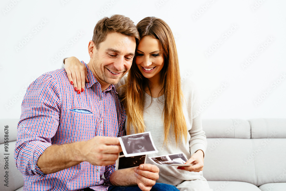 Young pregnant couple looking at an ultrasound scan Young pregnant couple looking at an ultrasound scan