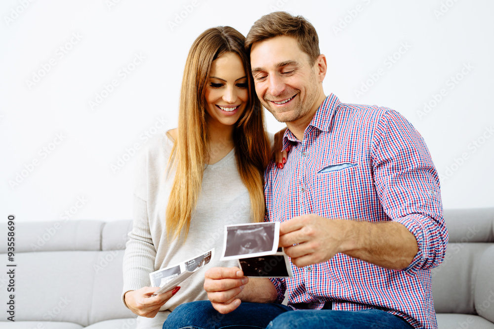 Pregnant couple browsing their future baby scans Pregnant couple browsing their future baby scans