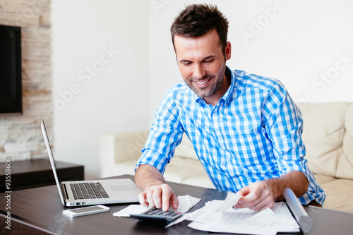 Young man paying his bills online