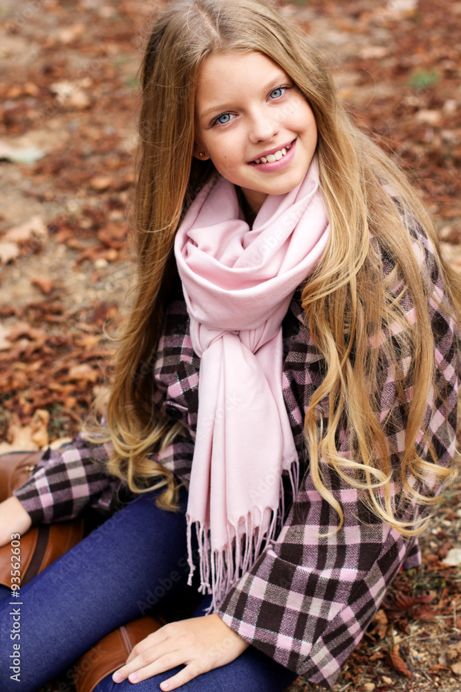 Cute girl is sitting on foliage in autumn park Cute girl is sitting on foliage in autumn park