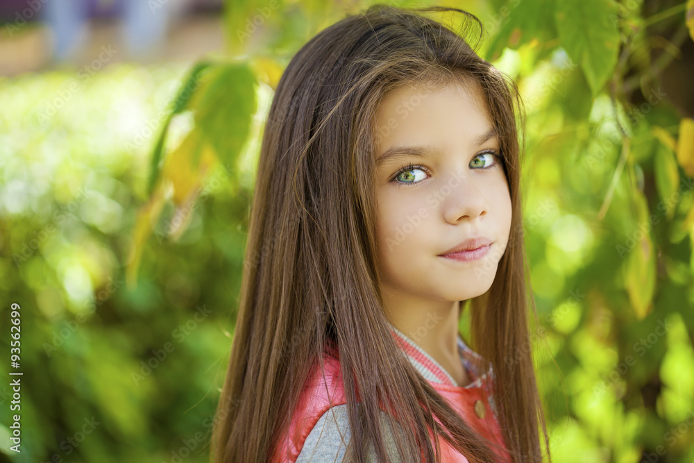 Beautiful little girl on green background of summer city park Beautiful little girl on green background of summer city park