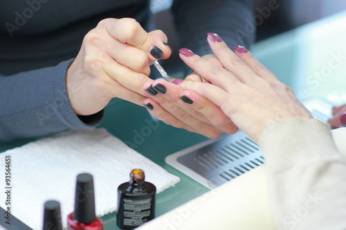 Manicure. Processing of nails by a nail file .Focus on the one hand and the customer master