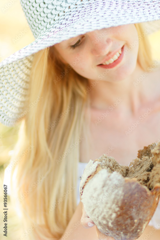 portrait of young beautiful woman holding fresh tasty bread in summer green park portrait of young beautiful woman holding fresh tasty bread in summer green park