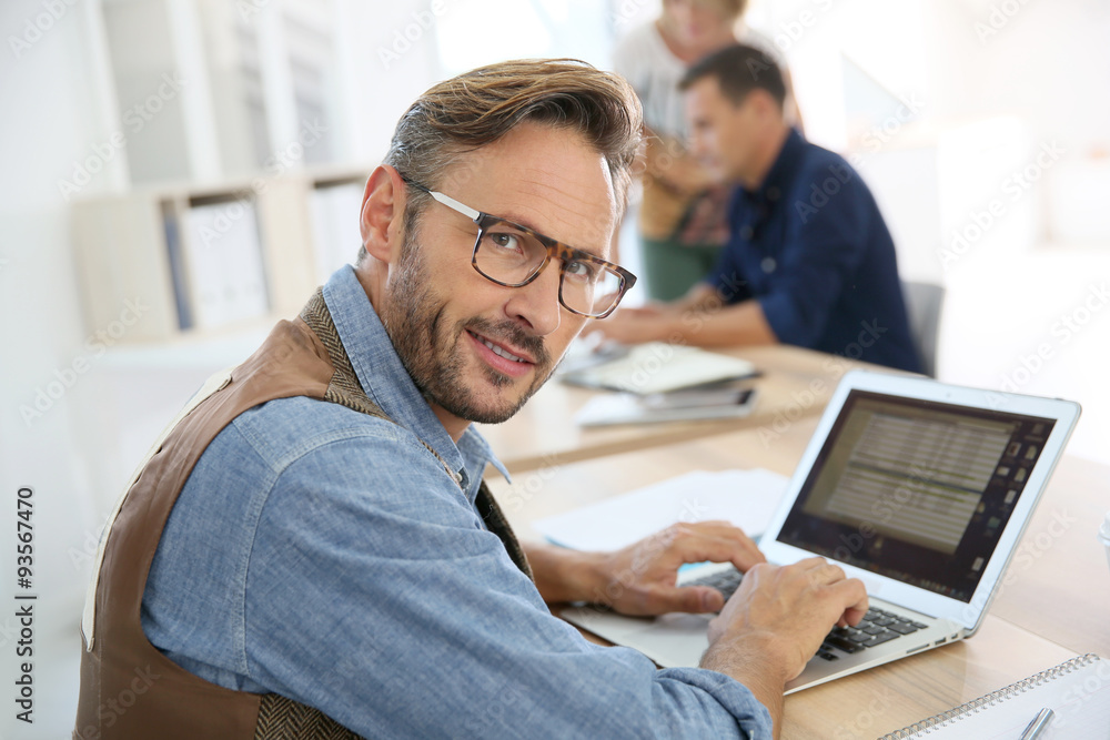 Portrait of trendy man working on laptop computer