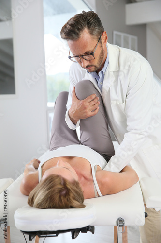 Physiotherapist stretching woman's leg
