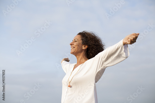 Fotografia Mujer madura feliz con los brazos abiertos al cielo