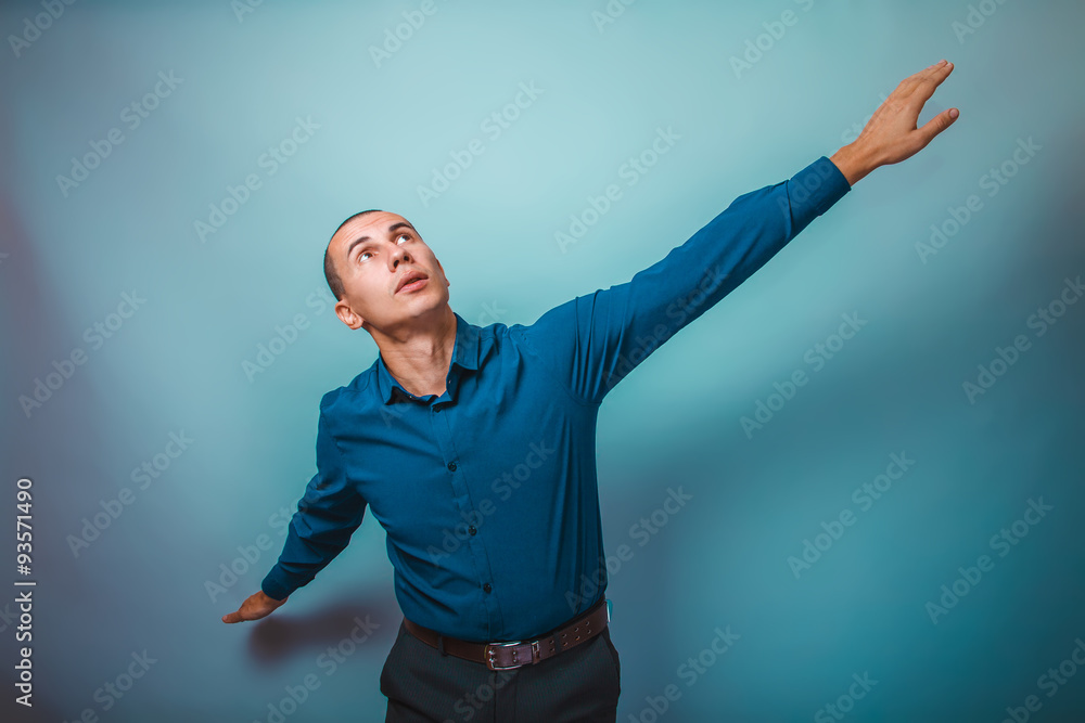 a man in a blue shirt European appearance spread his arms in a p
