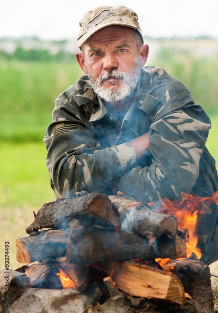 Man sitting near bonfire