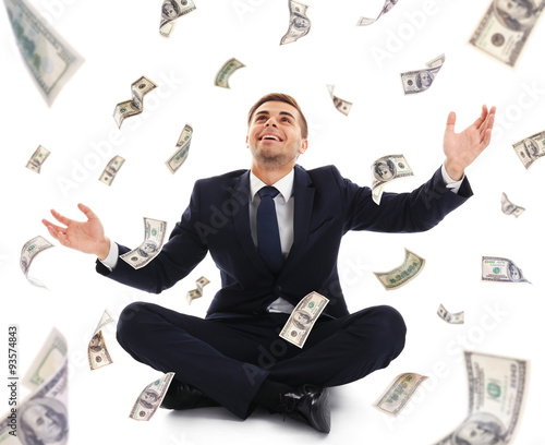 Businessman sitting on case in the rain of money