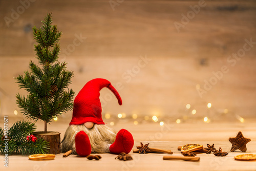 christmas tad sitting next to fir tree and x-mas decoration in f