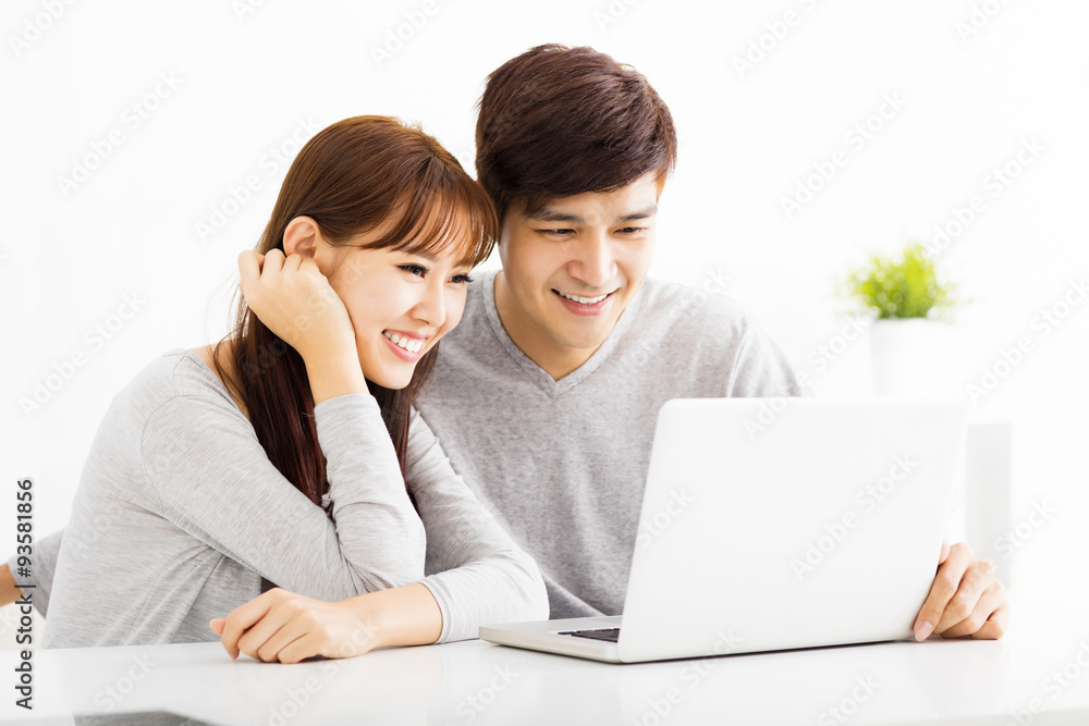 happy young Couple Looking at Laptop In living room happy young Couple Looking at Laptop In living room
