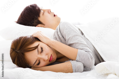 Billede på lærred young Woman covering ears  while  husband is snoring