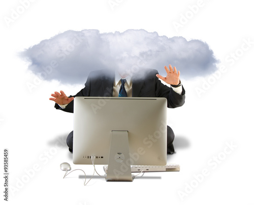 A business man in a suit is on a computer and his head is in the clouds, isolated on a white background