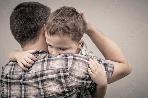 sad son hugging his dad photo