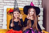 Girls, dressed up in Halloween costumes, show emotions of witches and vampires.