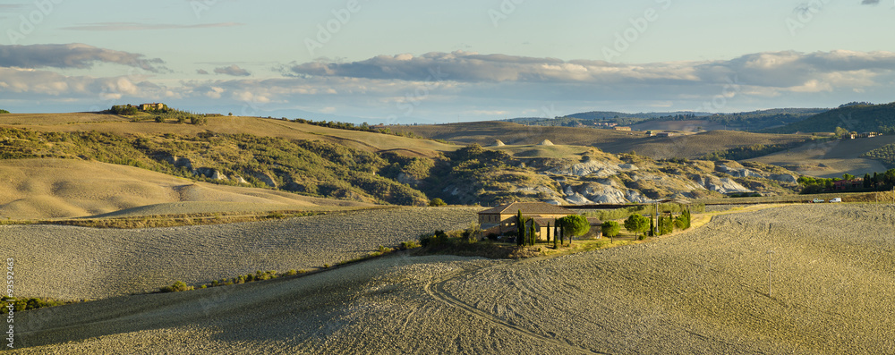Naklejka premium Farmers villas scattered on the Tuscan fields