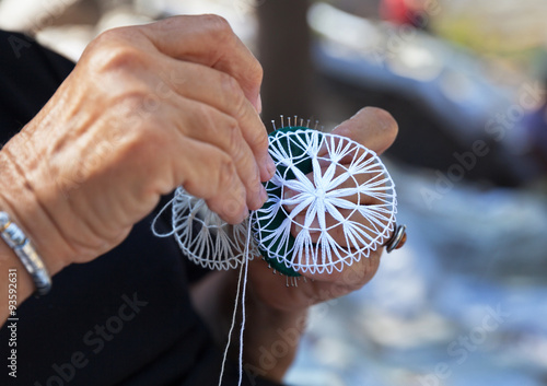 Hands lace makers at work. Elderly woman engaged in needlework
