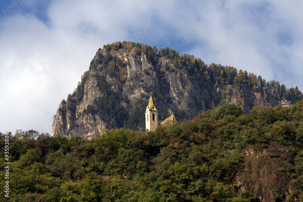Kirche im Wald vor einer felsigen Bergspitze
