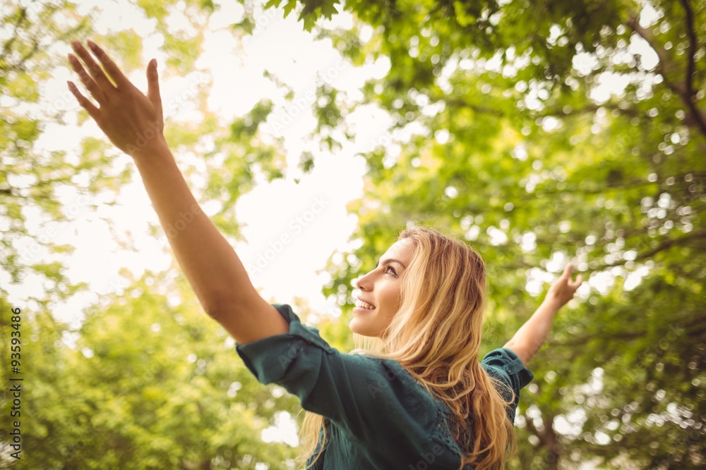 Beautiful smiling woman with arms raised at park Beautiful smiling woman with arms raised at park