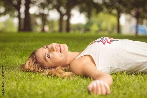 Beautiful woman looking up while lying on grass 
