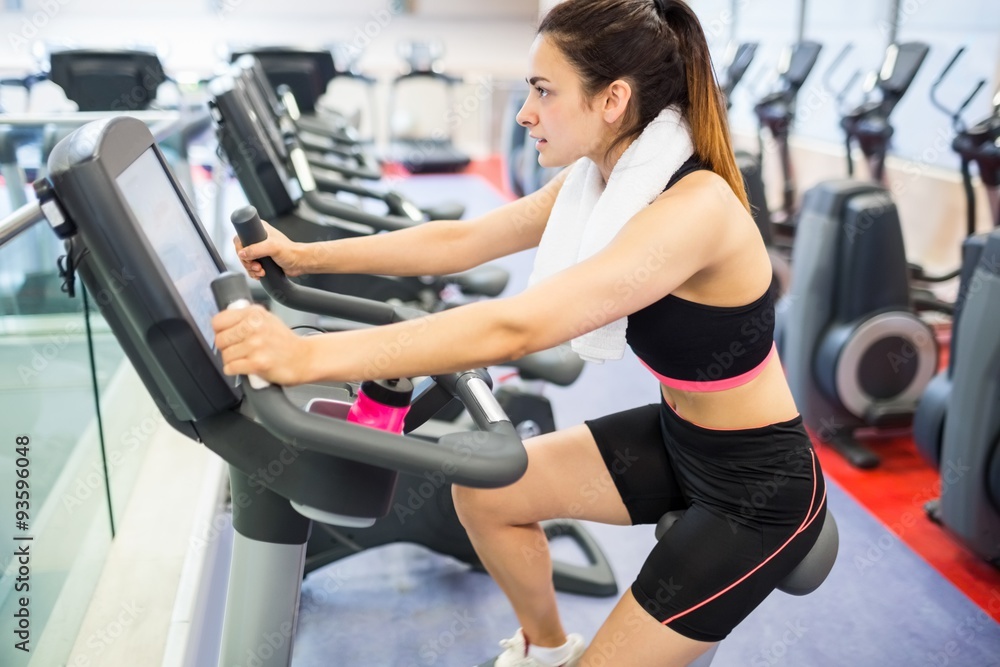 Focused woman using the exercise bike Focused woman using the exercise bike