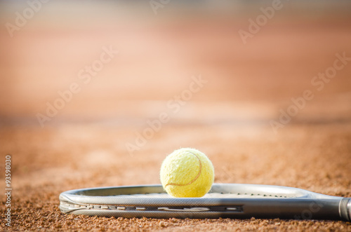 Tennis ball on a raquet in direct sunlight with a dramatic look suggesting tennis enlinghtment and talent