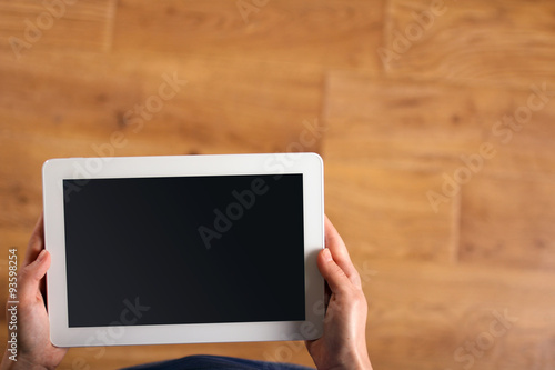 girl holds tablet on wooden background