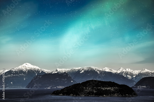 Northern lights aurora borealis in the night sky over beautiful lake landscape photo