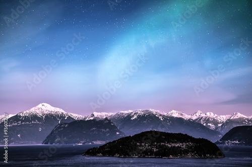 Northern lights aurora borealis in the night sky over beautiful lake landscape © surangaw