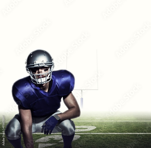 Composite image of american football player in uniform crouching